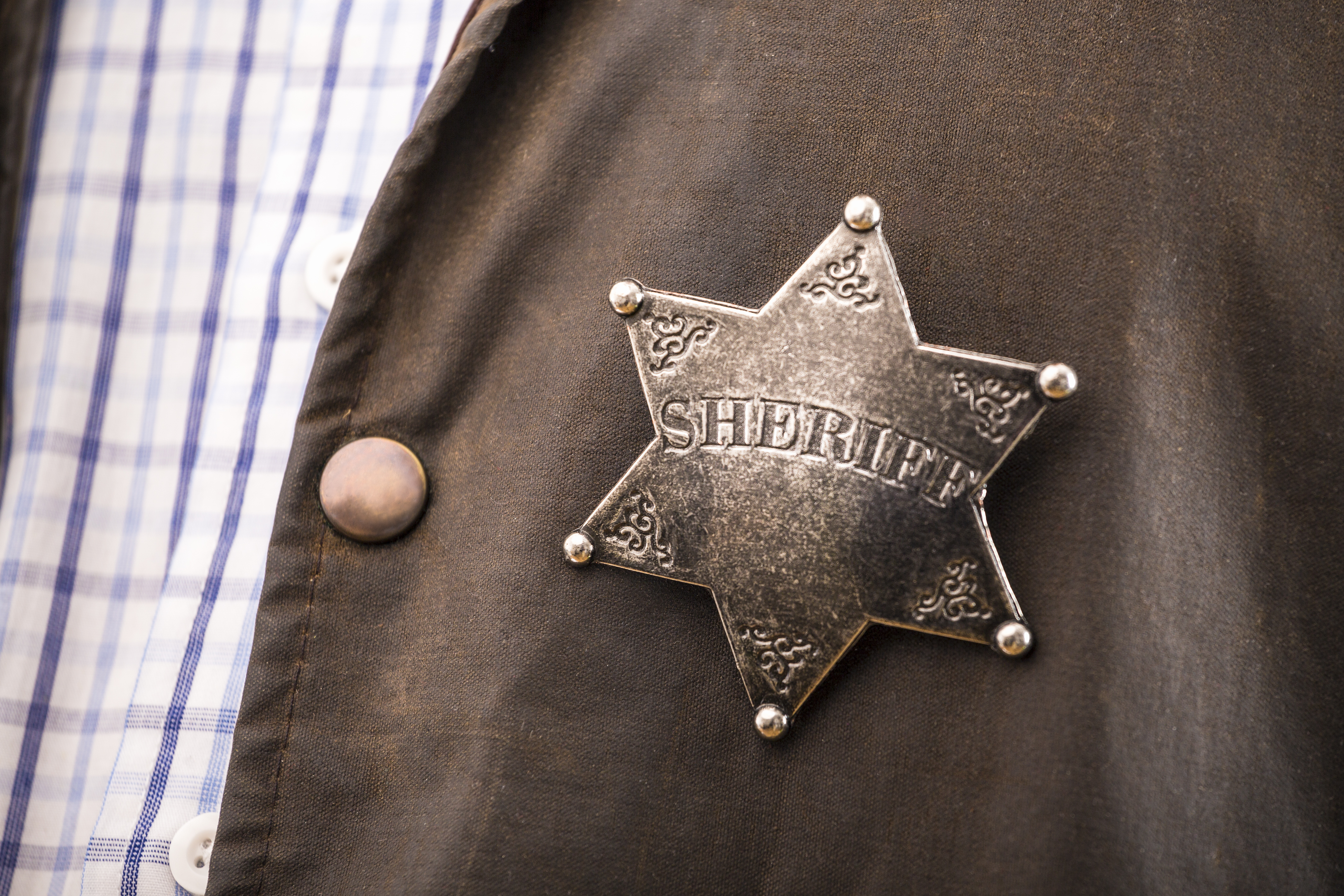 Close up of sheriff badge when on his coat duster