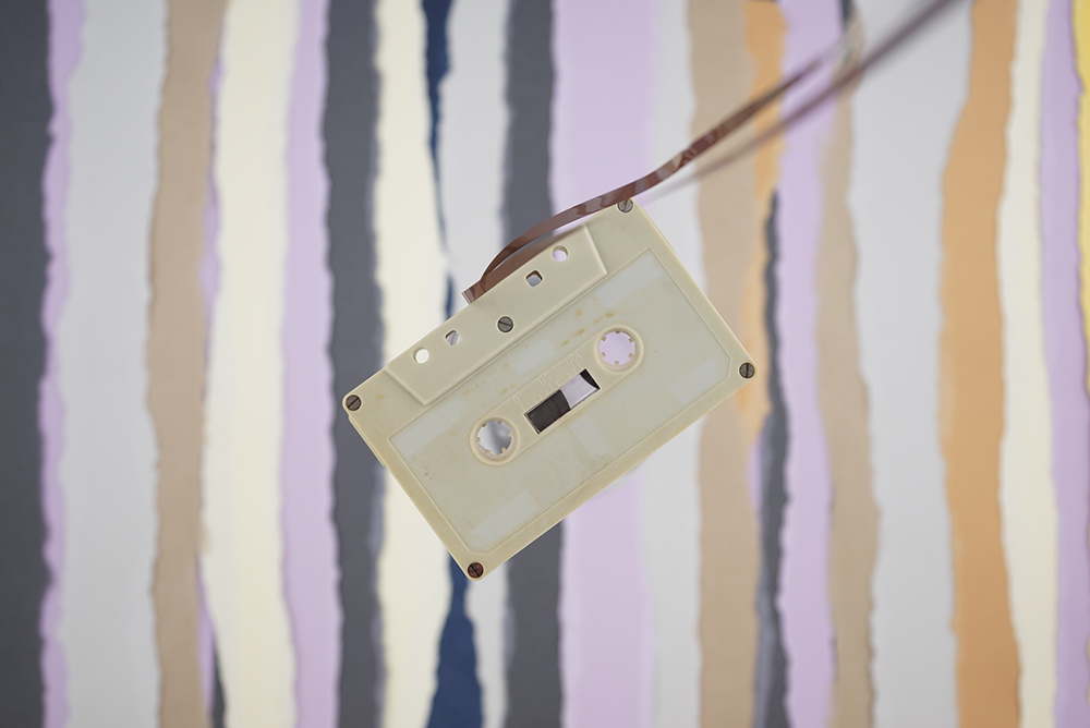 Cassette tape, classic vintage antique nostalgia flat lay on torn colored paper background.